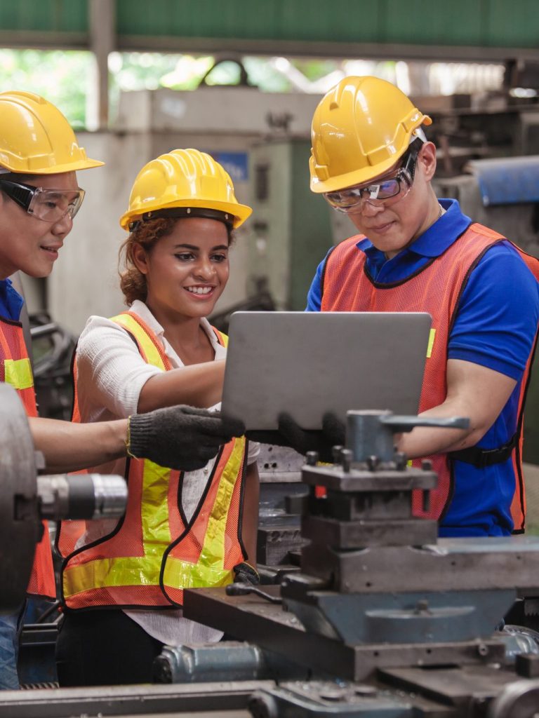 worker Industrial Engineers Talk with Factory Worker while Using Laptop. industrial worker is working. technician engineer and mentor checking process. machine metalworking industry concept copyspace